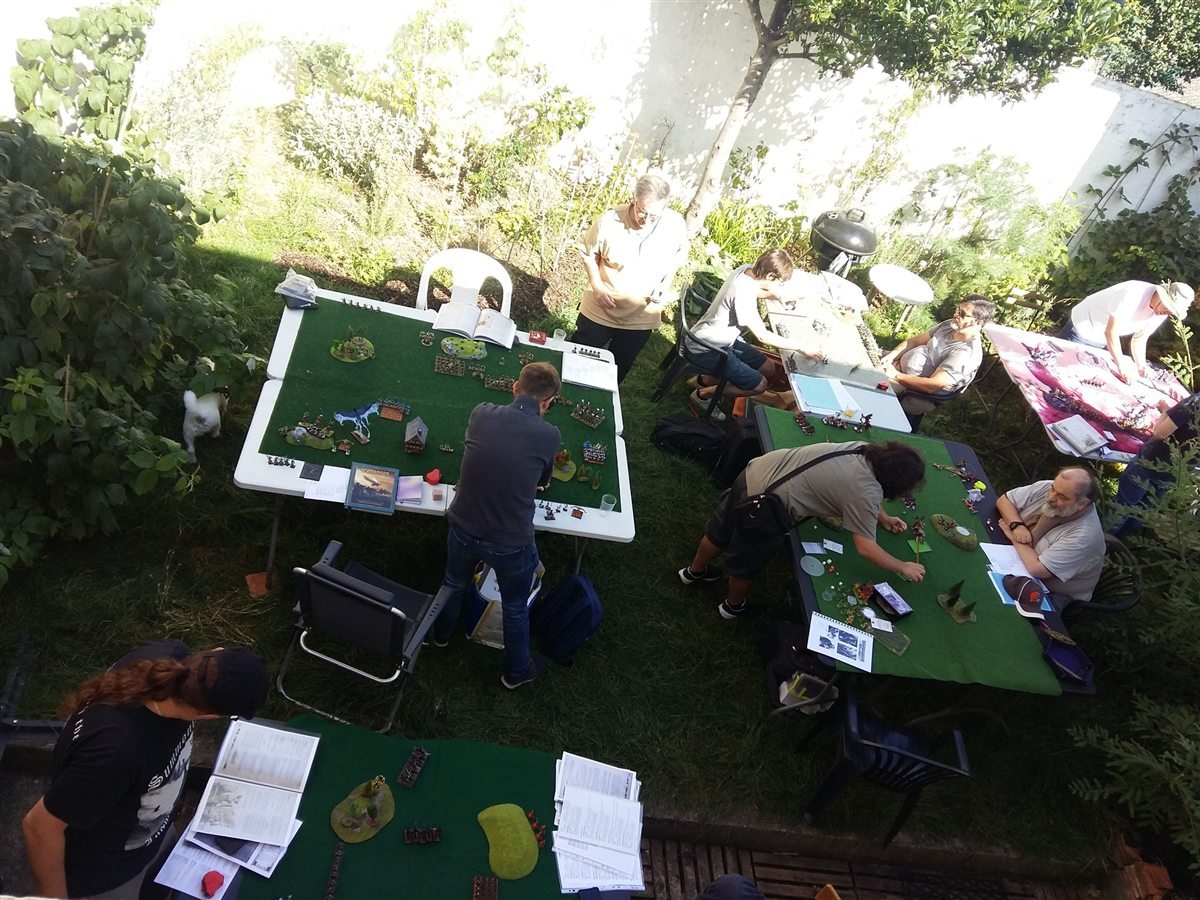 Vue en hauteur d'une partie de figurines sur plusieurs tables de jeu