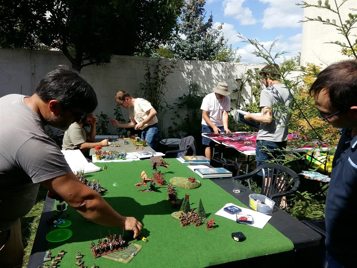 Partie de wargame en cours sur une table couverte de decors